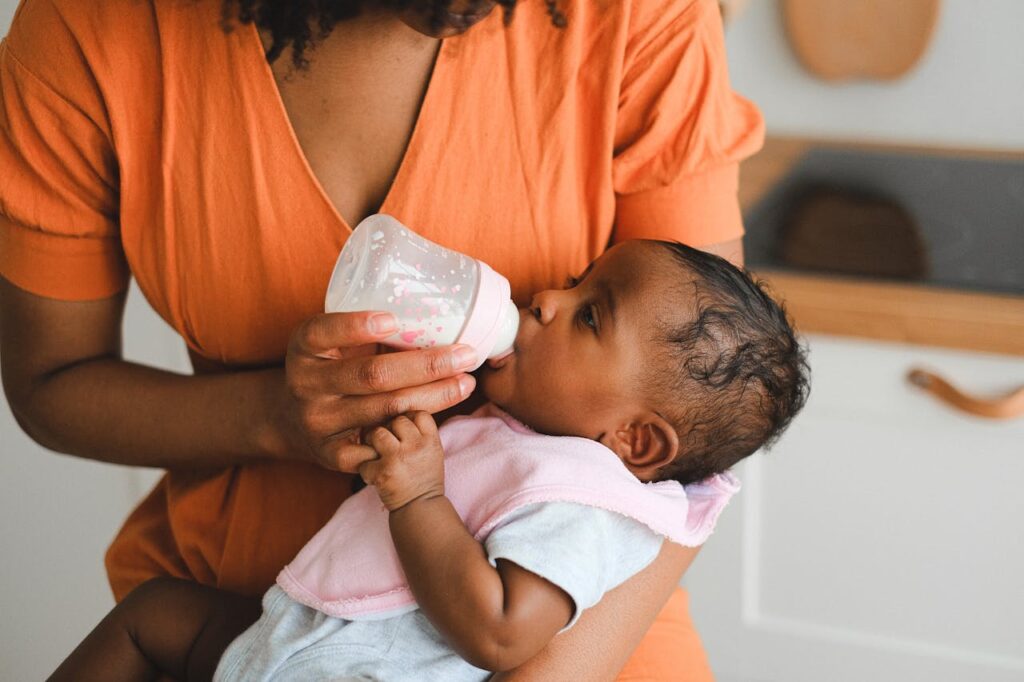 mom feeding baby formula milk